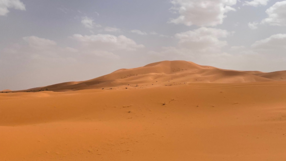 Image shows desert plain with a mountain in the distance.